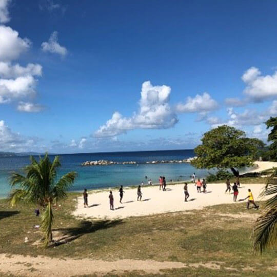 Beautiful beach in Jamaica with group of tourists in a fun activity.