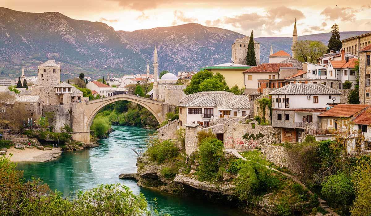 The historic 16th century city of Mostar in Bosnia with the river running past the ancient houses, one of the beautiful but unusual holiday destinations to visit in Europe.